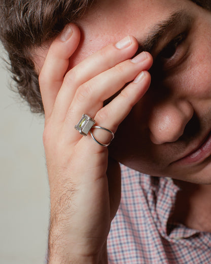 Anello in argento, cemento e pietra verde (peridoto).  Indossato al mignolo da un ragazzo,